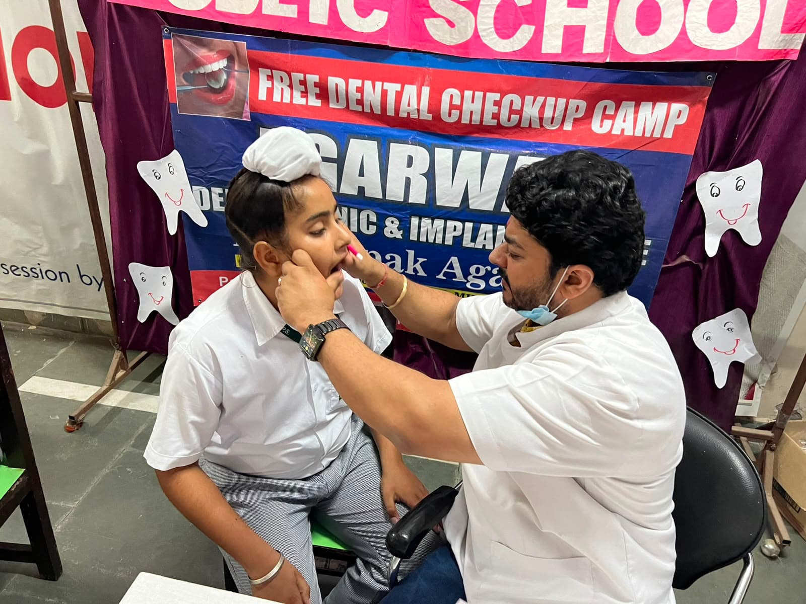 Dr. Deepak Agarwal conducting free dental checkup camp examination for students