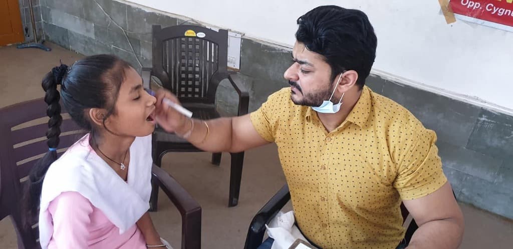Dr. Deepak Agarwal examining student during school oral health checkup