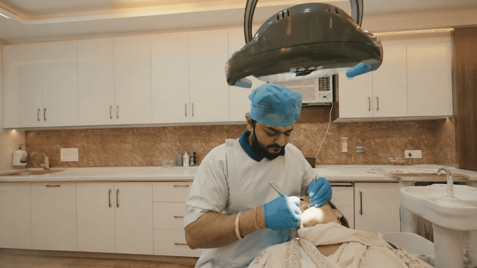 Dr. Deepak Agarwal treating a dental patient chairside at Agarwal Dental Clinic